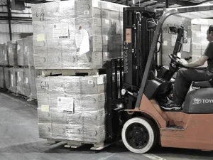 Warehouse forklift preparing palletized aroma ware products for international shipment to fragrance brands and distributors