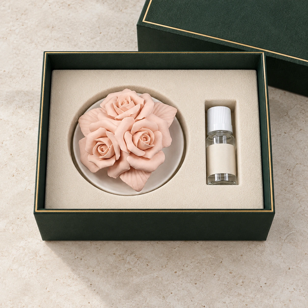 Trois roses en céramique rose et un flacon de parfum dans un coffret vert