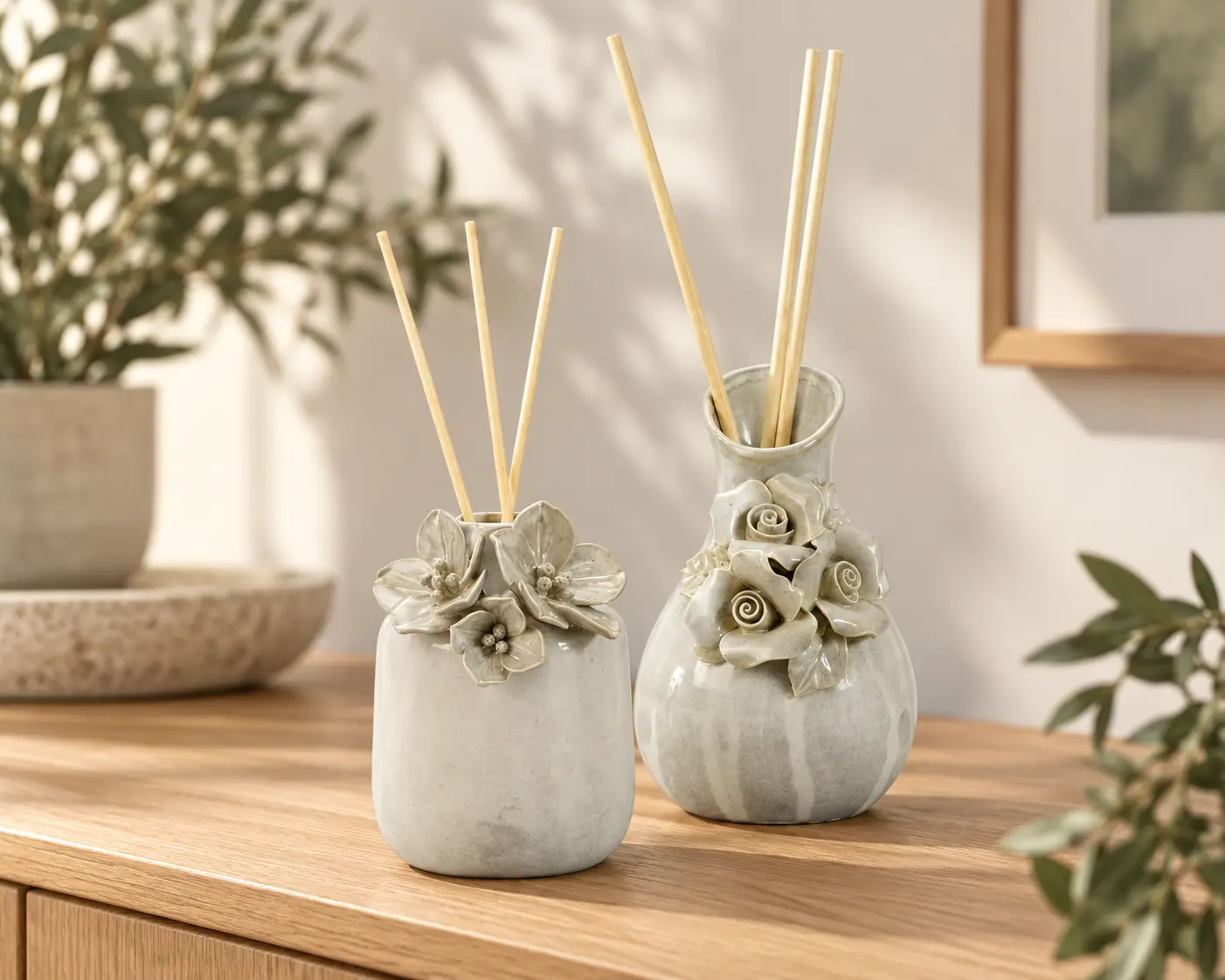 Floral ceramic diffuser vessels with reeds for a coordinated fragrance collection.