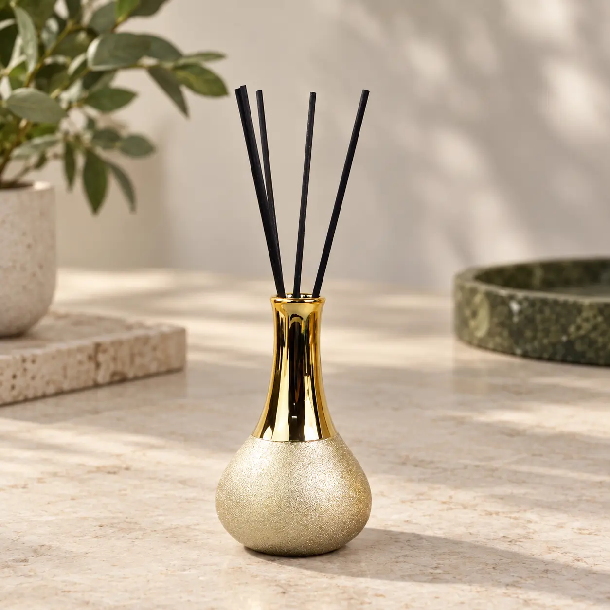 Gold diffuser vessel with black reeds showing the neck opening and reed arrangement.