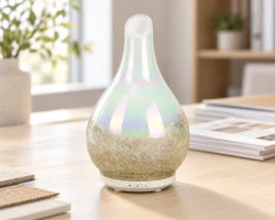Diffuseur à ultrasons en verre irisé en forme de poire, posé sur une table d'exposition lumineuse